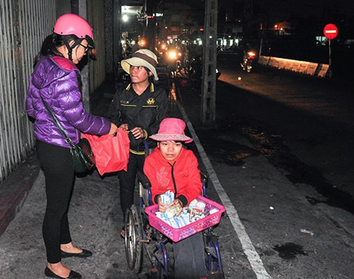 Thành viên nhóm Ong Vàng trao suất ăn khuya cho người lao động nghèo tại Đà Nẵng trong chương trình “Đêm ấm”.