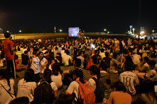 Du khách và người dân xem lễ khai mạc qua truyền hình trực tiếp bên ngoài sân khấu chính