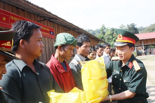 Đại tá Đoàn Thế Tùng, Phó Chính ủy Bộ CHQS tỉnh tặng quà cho nhân dân các bộ tộc Lào.                                                 Ảnh: THÙY DƯƠNG