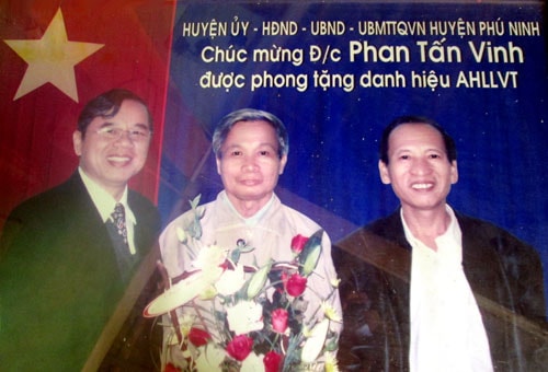 Lãnh đạo huyện Phú Ninh tặng hoa chúc mừng đồng chí Phan Tấn Vinh (giữa) được phong tặng danh hiệu Anh hùng lực lượng vũ trang nhân dân.