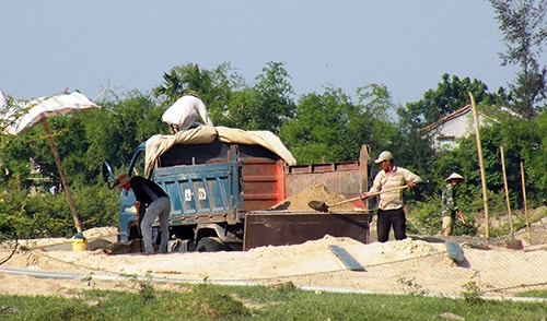 Xúc cát lên xe tải ben BKS 92H - 1326 vào chiều 24.4. Ảnh: Mai Nhi