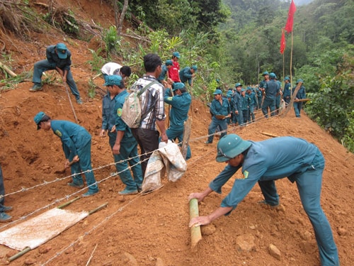 Lực lượng dân quân tự vệ tham gia giải tỏa điểm sạt lở tại thôn 2 (xã Trà Mai). Ảnh: D.Thái