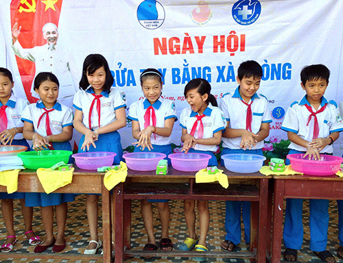 Các em học sinh trường Tiểu học Nguyễn Huệ (Điện Bàn) học cách rửa tay bằng xà phòng để phòng chống bệnh tay chân miệng.