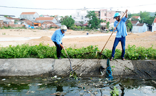 Các thủy nông viên của Cụm thủy nông Tam Dân đang vớt rác dưới lòng kênh Phú NinhẢnh: ĐOÀN ĐẠO
