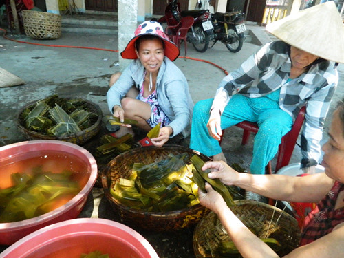 Những phụ nữ chung tay làm bánh ú tro cho cả xóm, thức lễ không thể thiếu trong mâm cúng mùng Năm. Ảnh: LÊ QUÂN