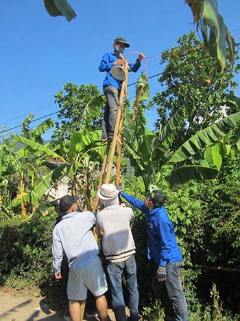 Thành viên CLB Áo xanh trang bị hệ thống điện để thắp sáng đường làng (ảnh 1) và tặng quà trẻ em nghèo ở Đại Sơn (Đại Lộc).