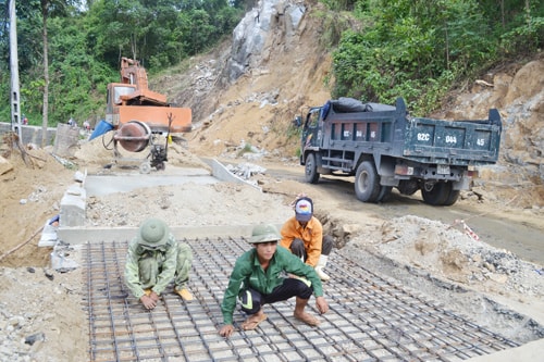 Công nhân Công ty CP Công trình GTVT Quảng Nam sửa chữa, khắc phục hậu quả lũ lụt trên tuyến ĐT611. Ảnh: CÔNG TÚ