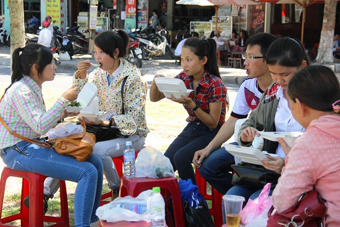 Các thí sinh tranh thủ ăn cơm trưa ngay tại gốc cây ven đường, chuẩn bị cho môn thi tiếp theo.