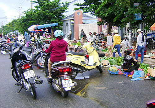 Nhiều khu, cụm công nghiệp trên địa bàn xuất hiện nhiều chợ tự phát ngay trên lòng đường. TRONG ẢNH: Chợ ở trục đường chính Cụm công nghiệp Trường Xuân, Tam Kỳ. Ảnh: T.LỘ