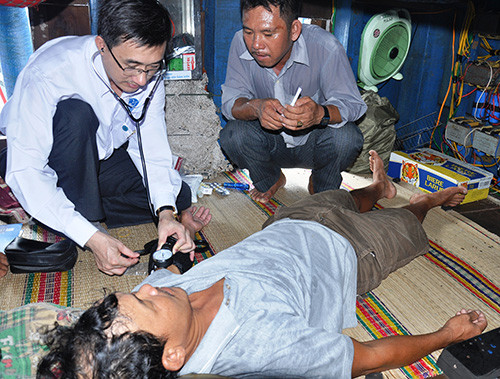 Bác sĩ Trần Văn Thuấn trực tiếp hướng dẫn các biện pháp sơ cấp cứu ban đầu cho ngư dân. Ảnh: VINH ANH