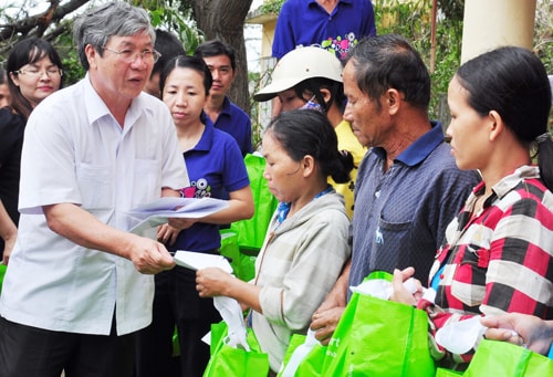 Chủ tịch Ủy ban MTTQ Việt Nam tỉnh - Lê Văn Lai trao tiền hỗ trợ người dân huyện Duy Xuyên bị thiệt hại do bão lụt. Ảnh: VINH ANH