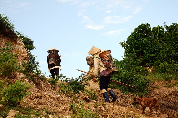 Người dân qua sông và trở về làng sau một ngày lao động vất vả.