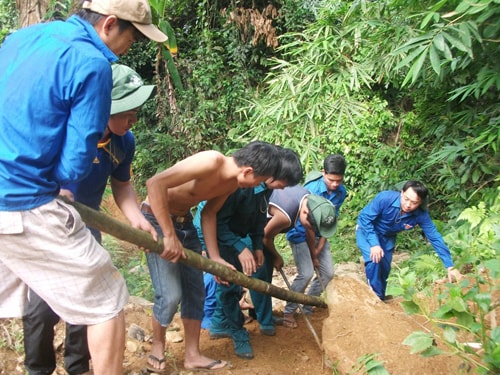 Thành viên đoàn tình nguyện Trường Đại học Quảng Nam làm đường dẫn vào các thôn 3 và 4 xã Trà Leng. Ảnh: VĂN HÀO