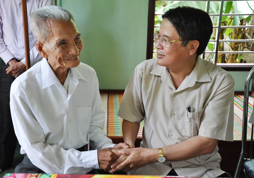 Bí thư  Tỉnh ủy Nguyễn Đức Hải thăm hỏi, chúc sức khỏe lão thành cách mạng Trần Ngọc 70 năm tuổi Đảng. Ảnh: XUÂN NGHĨA