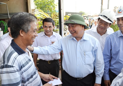 Phó Thủ tướng Nguyễn Xuân Phúc trò chuyện với người dân bị ảnh hưởng tại Núi Thành.Ảnh: CÔNG TÚ