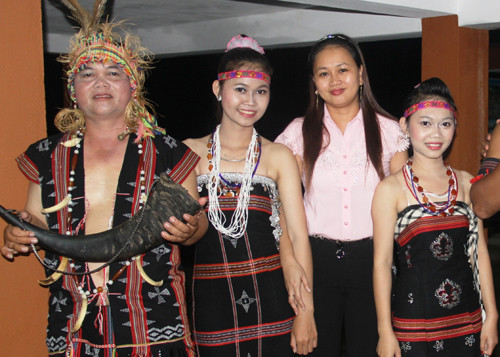 Du khách chụp ảnh cùng anh Alăng Sơn và hai cô con gái Alăng Thị Pari và Alăng Thị Parai tại lễ hội.