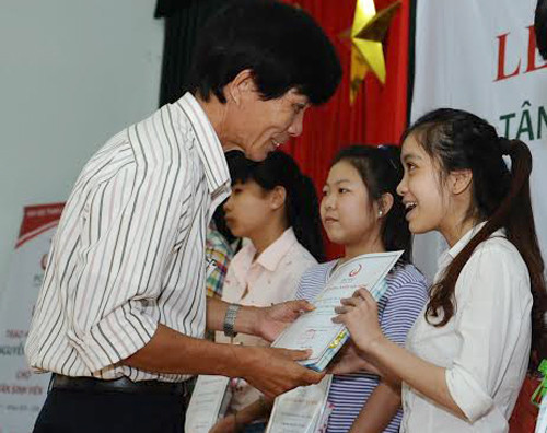 Ông Nguyễn Sự - Bí thư Thành ủy Hội An trao học bổng Nguyễn Thị Bình cho các tân sinh viên.