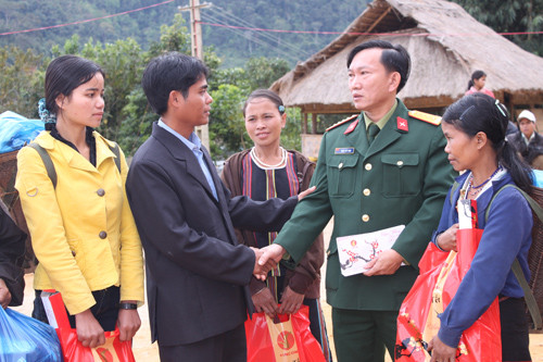 Đại tá Đoàn Thế Tùng, Phó Chính ủy Bộ CHQS tỉnh tặng quà cho đồng bào dân tộc thiểu số.                                                              Ảnh: Tuấn Anh