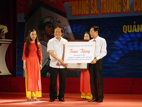 Leader of the Ministry of Information and Communication (left) gifts all documents and objects of the exhibition to Quang Nam province.