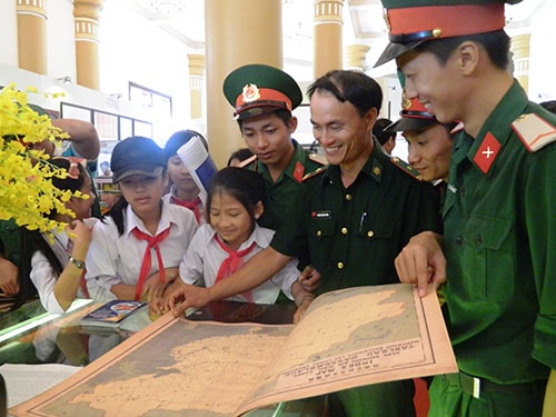 Soldiers and teenagers watching the maps and documents on Vietnam’s sovereignty over the Hoang Sa and Truong Sa archipelagos.