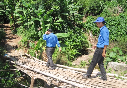 Những cây cầu treo hư hỏng ở Ca Dăng được đoàn viên thanh niên trong xã kịp thời sửa chữa. ảnh: C.NỮ