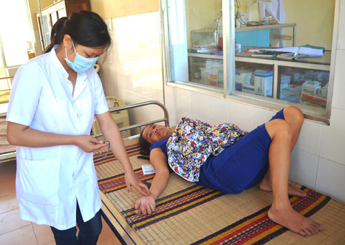 Y sĩ Phạm Thị Dung đang chăm sóc người bệnh ở Bệnh xá quân dân y kết hợp xã đảo Tân Hiệp. Ảnh: N.Q.V