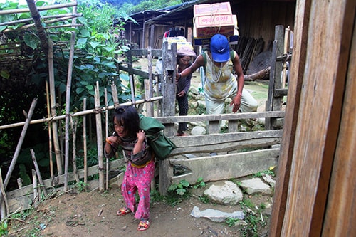 Mẹ con chị Cang gùi hàng thuê về nóc.