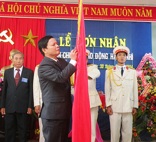 Đồng chí Lê Thân – Bí thư Huyện ủy Điện Bàn gắn Huân chương lên Cờ truyền thống của xã.