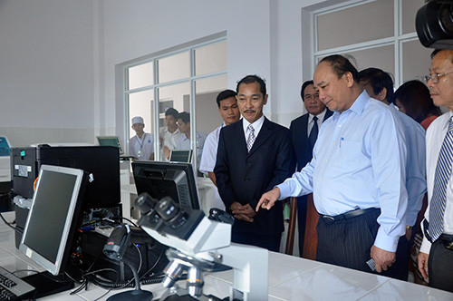 Giám đốc Bệnh viện Đa khoa Thăng Hoa - Nguyễn Thanh Phước (bên trái) giới thiệu với Phó Thủ tướng Nguyễn Xuân Phúc hệ thống trang thiết bị của đơn vị. Ảnh: NG.ĐOAN