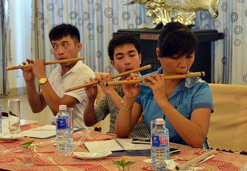 Các học viên tập cách cầm sáo.