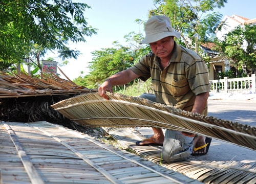 Anh Lê Công Thắng, chủ một cơ sở sản xuất tre dừa nước Cẩm Thanh chuẩn bị những tấm lợp để chở đi làm nhà lá cho khách hàng.  Ảnh: V. ANH