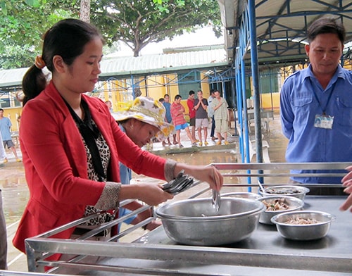 Nhân viên Công ty TNHH Phát triển công nghệ - tin học Vũ Long chuẩn bị cơm trưa cho người tâm thần. Ảnh: BẢO NGUYÊN.