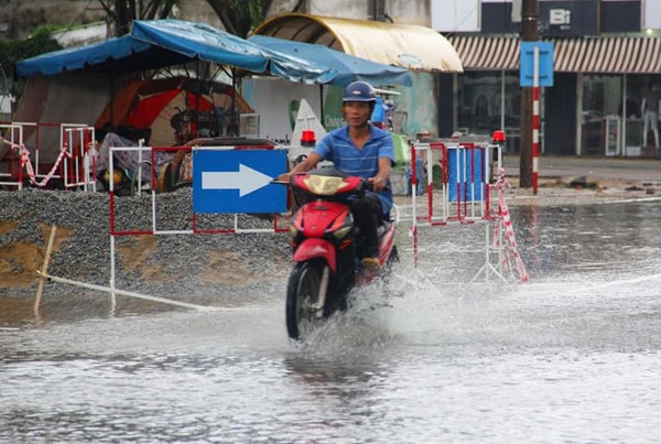 Đường ngập, các tài xế xe tải tranh thủ dùng nước mưa để rửa xe.