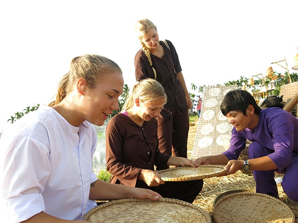 Còn Lill Mari Mundal (19 tuổi), người Na Uy dù đã cố vẫn không thể nào nhóm cho được hạt gạo trên sàng, đành phải buột miệng, tấm tắc khen bằng tiếng Việt lơ lớ “giỏi quá!”.