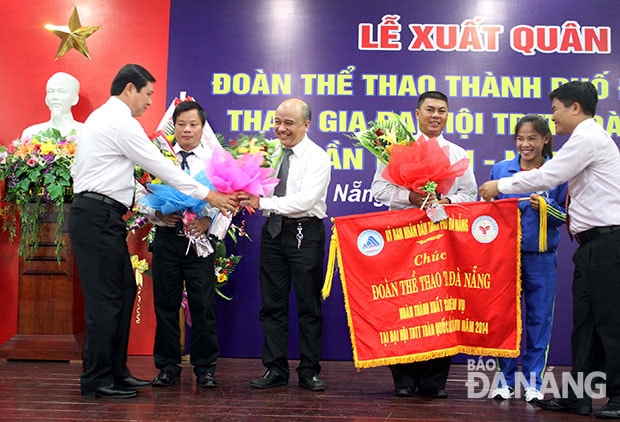 Phó Chủ tịch UBND thành phố Huỳnh Đức Thơ (bìa trái) và Giám đốc Sở VH-TT&DL Ngô Quang Vinh (bìa phải) tặng hoa cho đại diện Đoàn thể thao Đà Nẵng tham gia tranh tài tại Đại hội TDTT toàn quốc lần thứ 7 (2014).