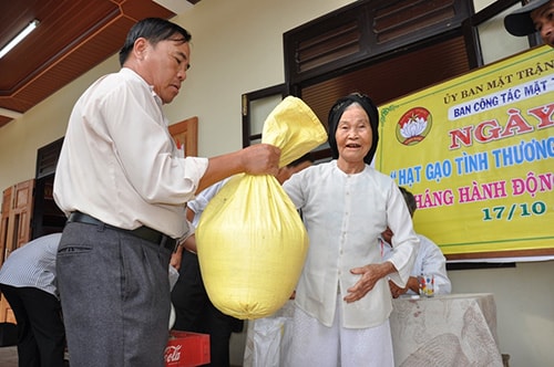 Bà Lương Thị Nguyệt (tổ 5, thôn Phiếm Ái 2) nhận gạo giúp đỡ của bà con trong thôn. Ảnh: VINH ANH