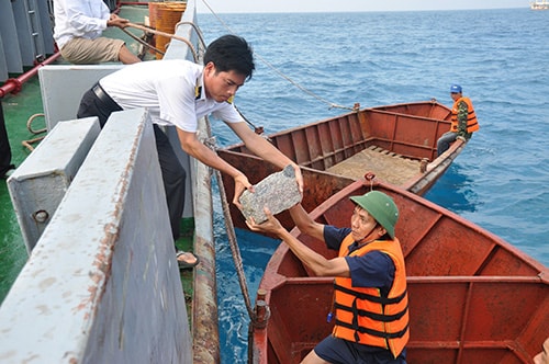 Những viên đá đầu tiên từ đất liền được chuyển ra Trường Sa xây dựng đảo Đá Tây A trong những ngày bão gió. Ảnh: Tấn Vũ