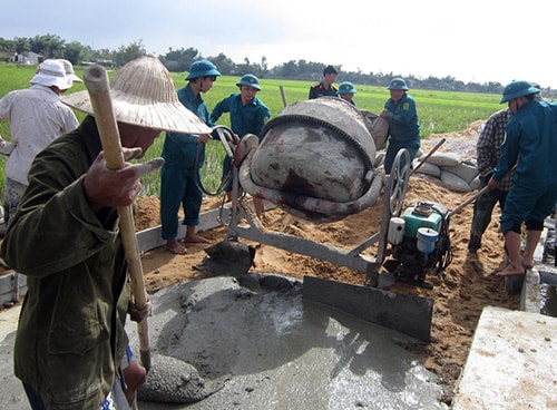 Lực lượng vũ trang huyện Quế Sơn giúp dân làm đường bê tông tại xã Hương An. Ảnh D.T