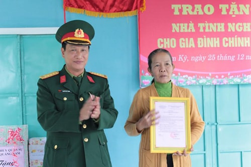 Đại tá Nguyễn Huy Động - Phó Chính ủy Bộ CHQS tỉnh trao quyết định bàn giao nhà cho bà Phạm Thị Kiên.