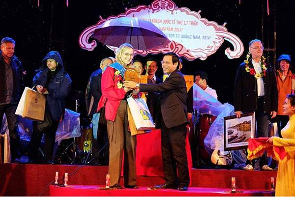 Phó Chủ tịch UBND tỉnh Nguyễn Chín tặng hoa, chúc mừng vị khách thứ 1,7 triệu đến Quảng Nam ngay dịp năm mới 2015. Ảnh: NGUYÊN KHÔI