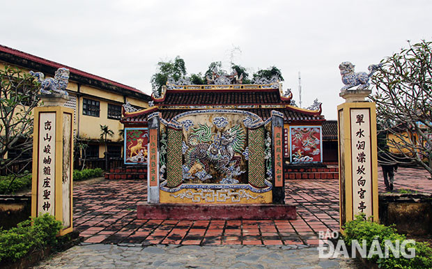 Bước qua cổng tam quan là đến các trụ biểu đứng cùng bình phong được đặt phía . Đây được xem như là một tam quan nội của đình. Trên thân trụ đều có các câu đối. Bình phong xây theo kiểu cuốn thư, mặt trong là hình hổ, mặt ngoài là hình long mã được đắp nổi. 