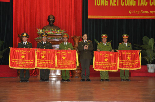 Thừa ủy nhiệm của Bộ trưởng Bộ Công an, Trung tướng Nguyễn Xuân Mười trao cờ của Bộ cho Công an các đơn vị địa phương có thành tích xuất sắc trong phong trào thi đua năm 2014. 
