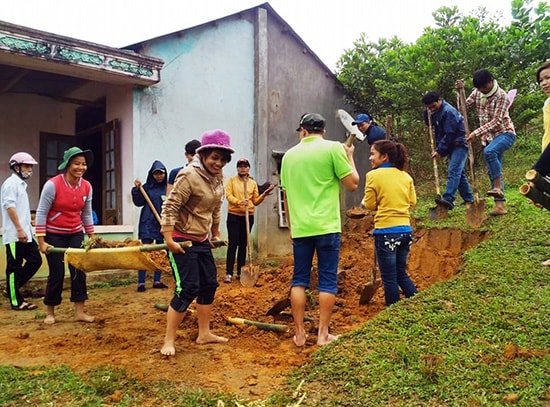 Thanh niên tình nguyện giúp san ủi nền nhà cho hộ Alăng Pháo.  Ảnh: C.T.V