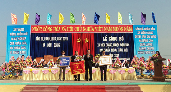 Phó Chủ tịch UBND tỉnh Huỳnh Khánh Toàn trao quyết định công nhận Điện Quang đạt chuẩn xã nông thôn mới.Ảnh: PHẠM LỘC