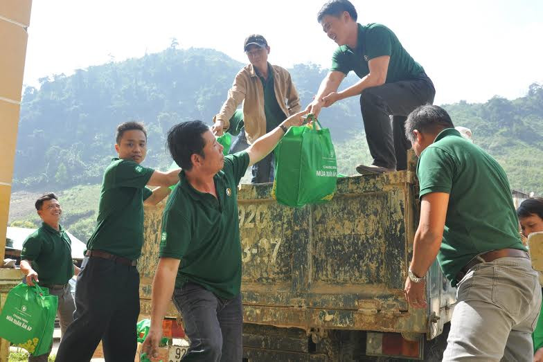 Các thành viên đoàn từ thiện của Công ty TNHH Nhà máy Bia Việt Nam chuyển quà tết đến đồng bào vùng cao. Ảnh: VINH  ANH