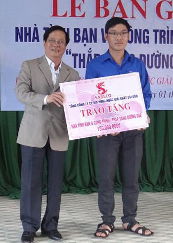 Ông Phạm Nam Chinh - Phó Giám đốc SABECO trao Nhà tình bạn và công trình thắp sáng đường quê.