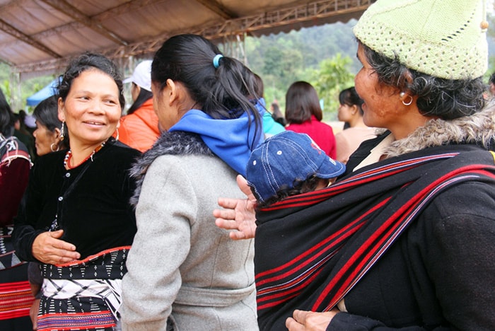 Các bà mẹ, phụ nữ Cơ Tu xúng xính trong trang phục truyền thống, cùng địu con đến xem hội.