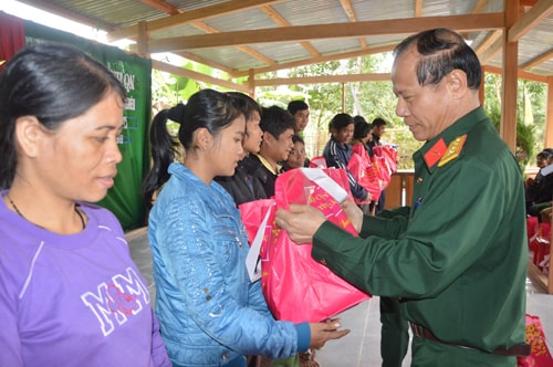 Đại tá Phan Văn Thu, Chỉ huy trưởng Bộ CHQS tỉnh tặng quà cho bà con xã A Tiêng, huyện Tây Giang.                     Ảnh: TUẤN ANH