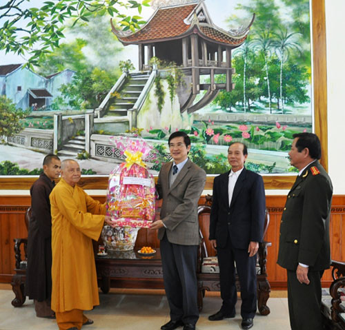 Phó Bí thư Thường trực Tỉnh ủy Nguyễn Ngọc Quang tặng quà  Ban trị sự Phật giáo tỉnh. Ảnh: XUÂN NGHĨA