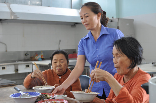 Chị Đinh Thị Minh Hội tận tình chăm lo từng bữa ăn cho người có công. Ảnh: HÀN GIANG